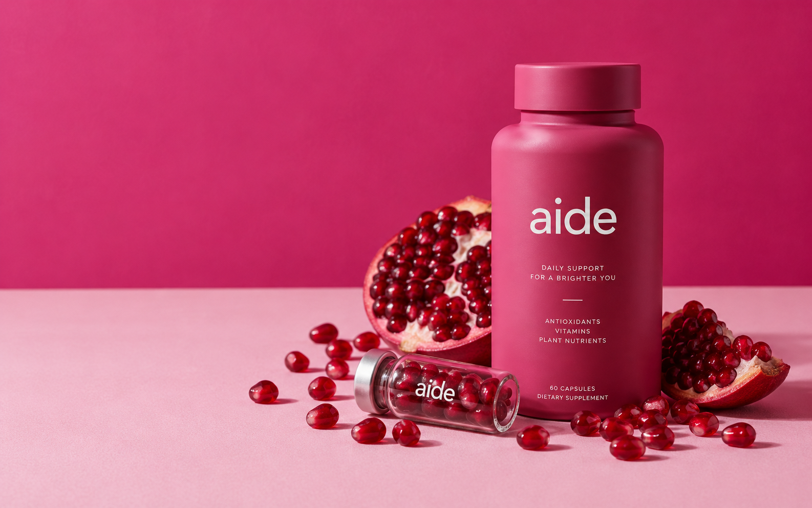 Magenta aide bottle surrounded by pomegranate seeds