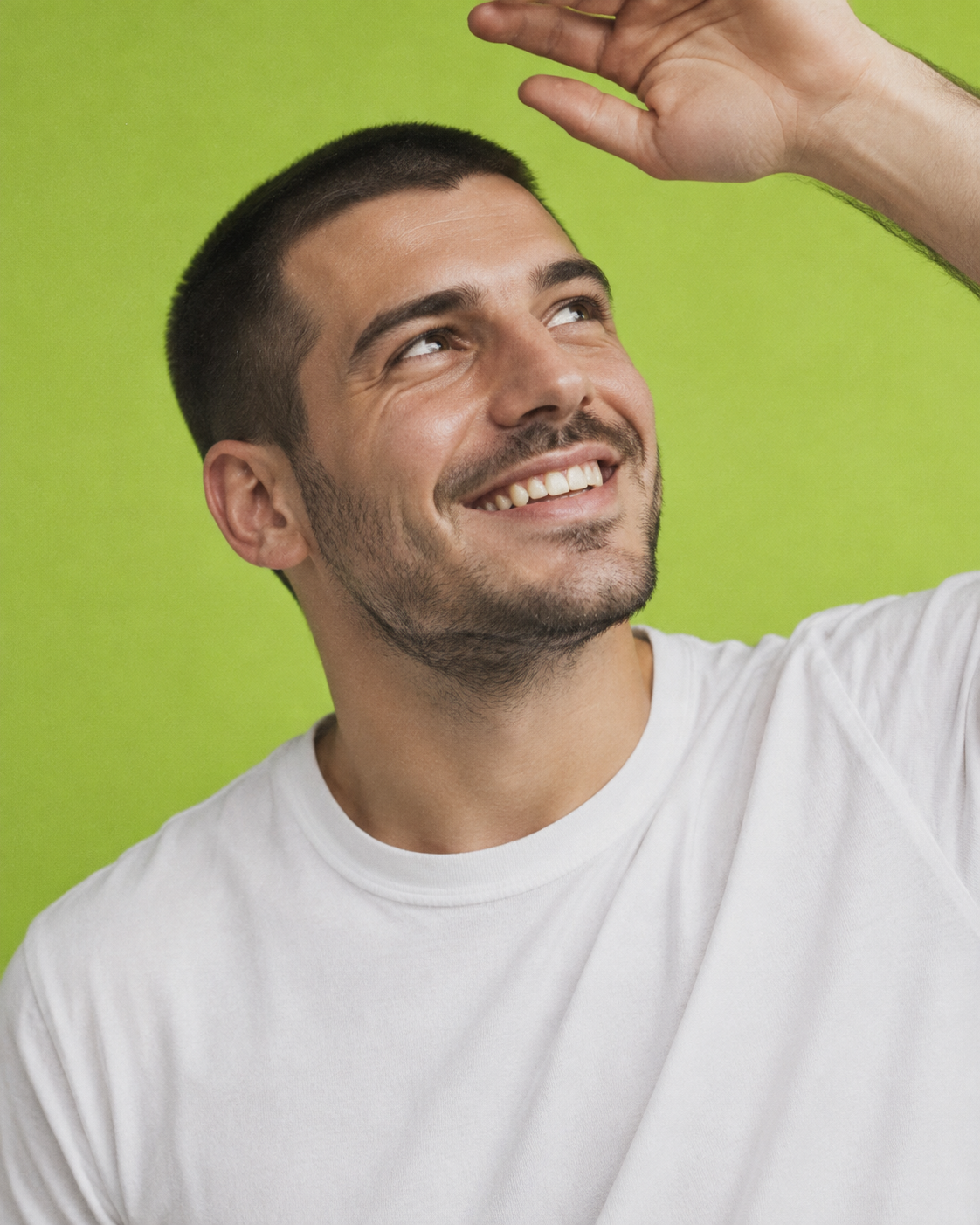 Smiling man looking upward against a lime green backdrop